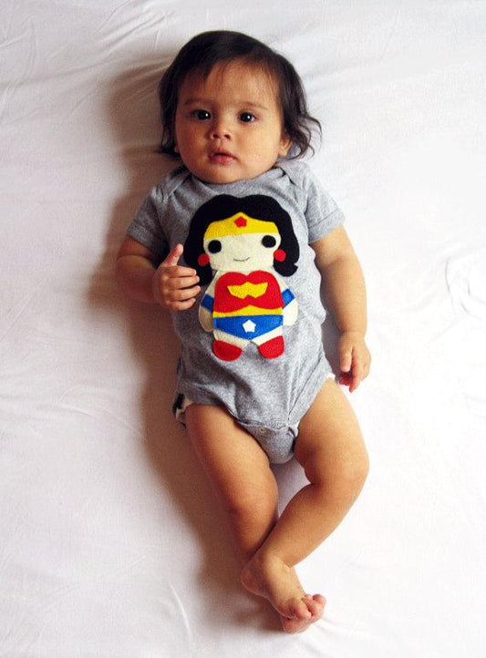 Your little one won't be alone because Wonder Girl is here to protect him/her! Imagine the little one wearing this adorable onesie! Sure to catch everybody's attention!! Makes a perfect gift too!  Handmade and hand-stitched! Materials: felt pieces appliqued to the 100% cotton onesie. This infant bodysuit is made to order and with 100% love!   Girl power! 