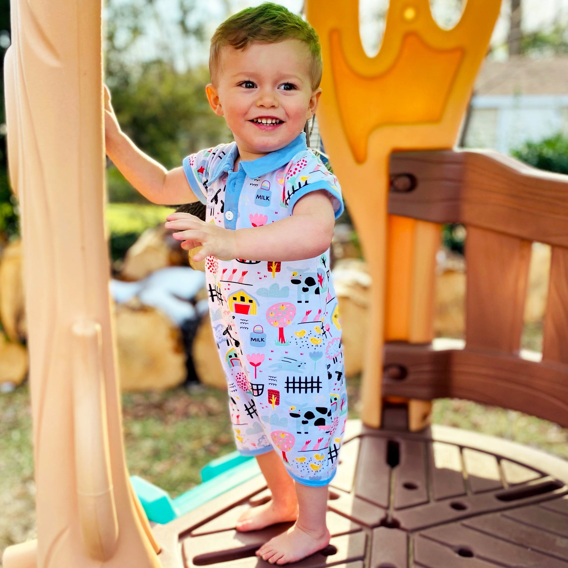 AnnLoren Boys One Piece Short Sleeve Romper. Fun Farm Animal Print with blue collar and 2 buttons in front. Snaps at inseam for easy changin